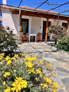 a patio with yellow flowers in front of a house at Koeni House in Argalasti