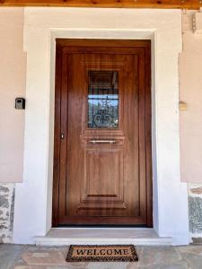 a wooden door with a welcome sign in front of it at Koeni House in Argalasti +31 photos