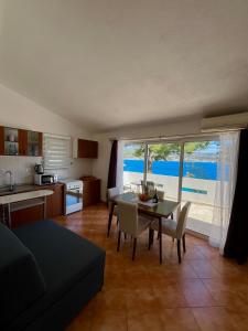 a living room with a table and chairs and a kitchen at Bronislovas holiday home in Rogoznica