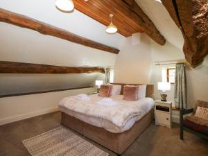 a bedroom with a bed in a room with wooden ceilings at Slade House in Ashbourne