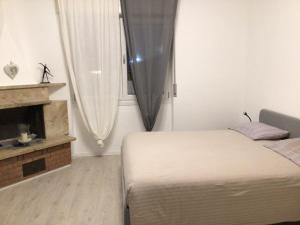 a small bedroom with a bed and a fireplace at Alla Pergola in Ceniga