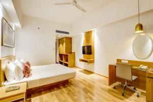 a hotel room with a bed and a desk at Lemon Tree Hotel Electronics City in Bengaluru