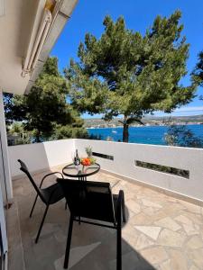 a patio with a table and chairs and a view of the water at Bronislovas holiday home in Rogoznica