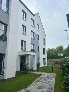ソポトにあるN736 Sopot Suite - 55m2 apartament premium z 2025 rokuの緑の庭のある白い建物