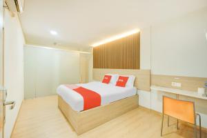 a bedroom with a bed and a table and a chair at Dancenter Tanjung Duren Near Mall Citraland Formerly Suba Hotel in Jakarta