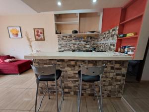 eine Küche mit einer Bar mit zwei Hockern in der Unterkunft Departamento don Pedro 1 in Posadas