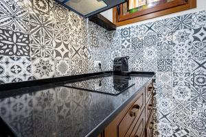 a kitchen with a counter top and tiles on the wall at Vintage Suite in Cagliari