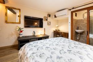 a bedroom with a bed and a television on the wall at Vintage Suite in Cagliari