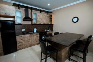 a kitchen with a table and a clock on the wall at Kottage ji in Bakuriani
