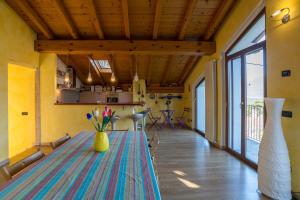 un comedor con una mesa con flores en un jarrón amarillo en Cremia Dreamhouse - Happy Rentals, en Cremia