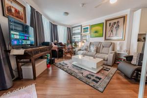Una sala de estar con un sofá y un piano. en Charlotte Street Towers, en Brisbane