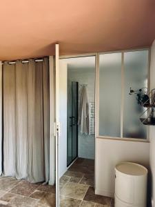 a bathroom with sliding glass doors and a toilet at La Maison Vivante, chambres d'hotes au coeur du Perche in Les Étilleux +36 photos