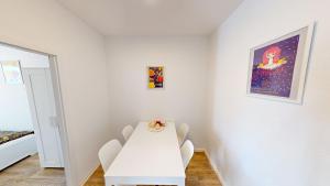 ein weißes Esszimmer mit einem weißen Tisch und Stühlen in der Unterkunft Wohlfühlapartment für 5 Personen, Haltestelle der Linie 5 in unmittelbarer Nähe, WLAN in Chemnitz