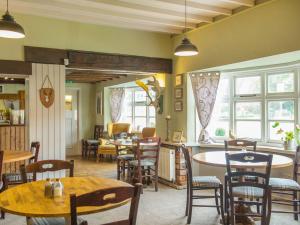 Un comedor con mesas y sillas y ventanas. en The Haughmond, en Shrewsbury