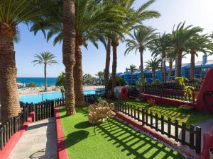 een resort met palmbomen en een zwembad bij Blue Horizon Retreat in Playa del Aguila