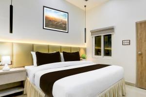 ein Schlafzimmer mit einem großen Bett und einem Fenster in der Unterkunft Collection O George Town in Colonelganj + 24 Fotos