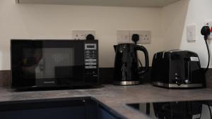 a microwave sitting on a counter next to a coffee maker at Luxury One Bedroom Flat - Cardiff City Centre in Cardiff +11 photos