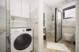 bagno bianco con lavatrice di Villa Tria Quercus with Rooftop Pool a Vodice