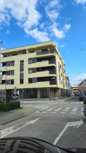 a large yellow building on a city street at Apartman Most in Bosanska Gradiška
