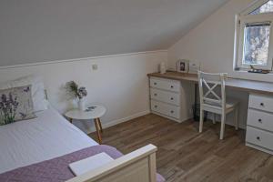 een slaapkamer met een bed, een bureau en een tafel bij Ledinić room in Mokošica