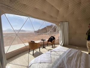 a bedroom with a bed and a view of the desert at Al-Faris Camp in Disah