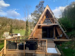 a frame house with a deck and a porch at La cabanA meublé de tourisme, 2 étoiles in Seix