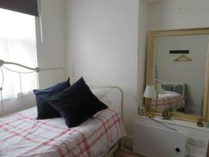 a bedroom with a bed and a mirror at The Pepper Pot Sleeps 4 Sunlit Garden in Exmouth