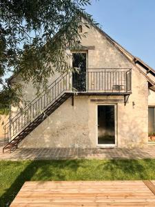 a house with a balcony on the side of it at La Maison Vivante, chambres d'hotes au coeur du Perche in Les Étilleux
