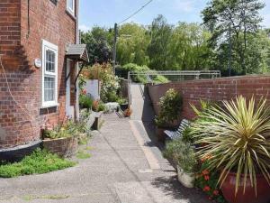 a garden outside a brick house with potted plants at The Pepper Pot Sleeps 4 Sunlit Garden in Exmouth +32 photos
