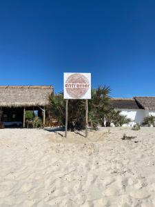 a sign on the beach in the sand at ENTREMER Maison du bout du monde in Belo