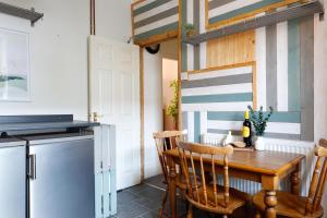 a small kitchen with a table and a refrigerator at Ashley Suite - Cozy 1BR Maisonette with Parking & WIFI in Barry +14 photos