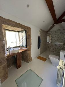 a bathroom with a sink and a toilet and a window at Casa Bretema Ferrol in La Cabana