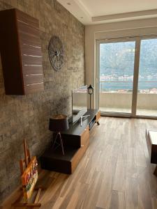 a living room with a clock on the wall at Enyana Family Apartment in Dobrota