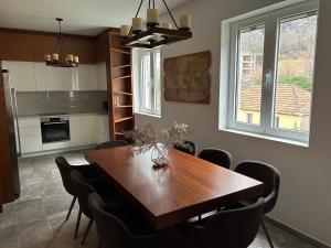 a dining room with a wooden table and chairs at Enyana Family Apartment in Dobrota