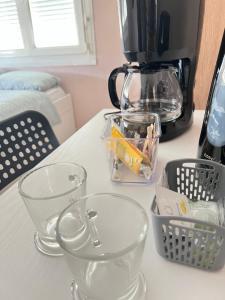 a counter top with clear dishes and a coffee maker at Chambre Privée au Cœur de Ville Toulouse in Toulouse