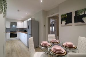 a kitchen and dining room with a glass table and chairs at Signature - Drumvale House in Chryston
