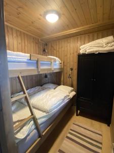 a bedroom with two bunk beds in a cabin at Sjusjøen Hytteutleie AS in Sjusjøen