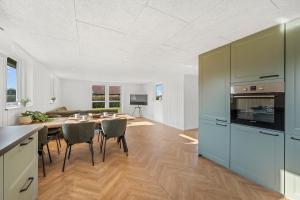 a kitchen and dining room with a table and chairs at Modern Holiday Home With 3 Bedrooms, Completely Renovated In 2025 And Located Close To Rinkøbing Fjord in Skjern