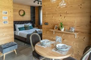 Les FourgsBoutique Hôtel - Notre Chalet的带床和木墙的卧室