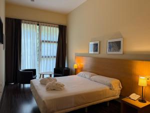 a hotel room with a bed with a towel on it at Hotel Balneario de Lanjarón in Lanjarón