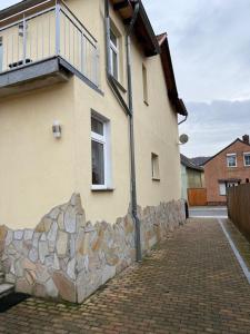 un edificio con un muro de piedra al lado de una casa en Ferienwohnung in Thale, en Thale