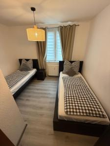 two beds in a room with a window at Dreamhopp28 - Küche, bis zu 4 Personen in Magdeburg