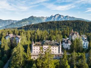 an aerial view of a mansion in the mountains at Romantik Hotel Schweizerhof & Spa Flims in Flims