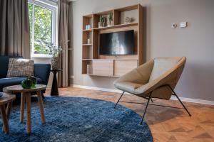 ein Wohnzimmer mit einem Stuhl und einem TV in der Unterkunft Residence Noordstaete vakantieappartement Lepelaar in Burgh Haamstede
