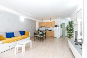 a living room with a yellow couch and a kitchen at Relax by the Sea at Medano Retreat Terrace Pool in El Médano