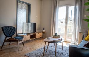 a living room with a tv and a couch and a table at Thessaloniki Boutique 3BD APT in Thessaloniki
