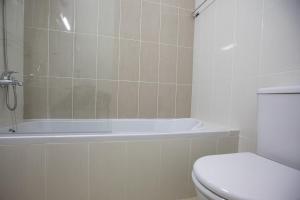 a bathroom with a toilet and a bath tub at Elysian Gem by Staycom in Paphos City +8 photos