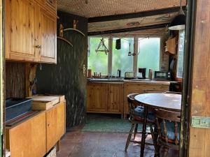 a kitchen with a table and a sink at Bungalow im Wald am See - Biberspur in Zieko