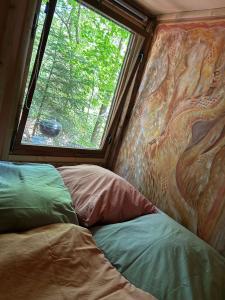a bedroom with a window and a bed in a trailer at Bungalow im Wald am See - Biberspur in Zieko