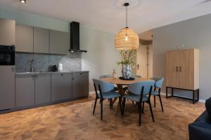 eine Küche und ein Esszimmer mit Tisch und Stühlen in der Unterkunft Residence Noordstaete - Vakantieappartement Lepelaar de Luxe in Burgh Haamstede